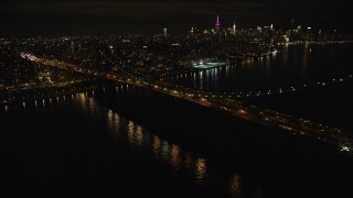 AX123_099E - 5.5K aerial stock footage approach the Williamsburg Bridge at Night in New York City