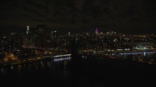 AX123_110E - 5.5K aerial stock footage of an orbit of the Manhattan side of the Brooklyn Bridge at Night in New York City