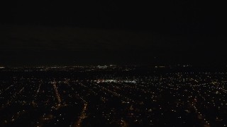 AX123_150E - 5.5K aerial stock footage of suburban neighborhoods and a bridge in the distance at Night in Queens, New York City