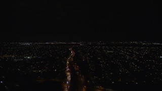 AX123_175E - 5.5K aerial stock footage pan across suburban neighborhoods and a strip mall at Night in Wantagh, New York