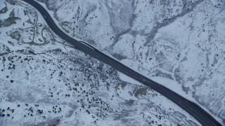 AX124_026 - 5.5K aerial stock footage of a bird's eye of a winter mountain highway at Sunrise in the Wasatch Range, Utah