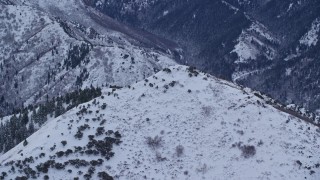 AX124_031E - 5.5K aerial stock footage of snowy top of Grandeur Peak in Winter at Sunrise in Utah