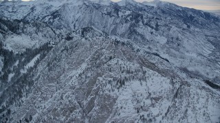 AX124_045 - 5.5K aerial stock footage of approaching the top of Mount Olympus with snow at winter sunrise in Utah
