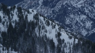 AX124_048 - 5.5K aerial stock footage orbit snowy slope of Mount Olympus at winter sunrise in Utah