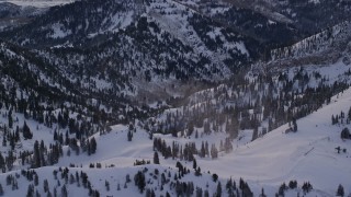 AX124_079 - 5.5K aerial stock footage orbit mountain snowdrifts at sunrise in the Wasatch Range of Utah