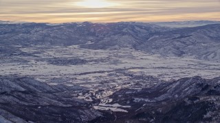 AX124_083 - 5.5K aerial stock footage orbit Heber Valley in winter snow at sunrise in Utah