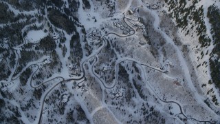 AX124_096 - 5.5K aerial stock footage of a bird's eye of mountain roads and homes with snow at sunrise in Park City, Utah