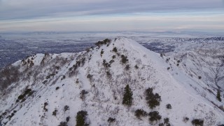 AX124_172E - 5.5K aerial stock footage fly over Grandeur Peak to reveal Salt Lake City at sunrise, Utah