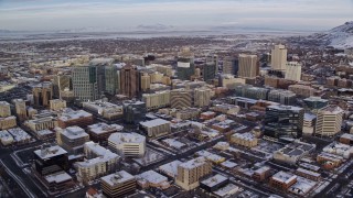 AX124_195E - 5.5K aerial stock footage approach wintery Downtown Salt Lake City, Utah with snow at sunrise