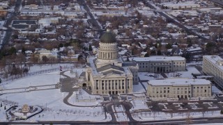 AX124_200E - 5.5K aerial stock footage of orbiting the Utah State Capitol with winter snow in Salt Lake City at sunrise