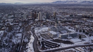 AX124_202E - 5.5K aerial stock footage orbit Utah State Capitol and Downtown Salt Lake City with snow at sunrise
