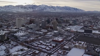 AX124_205 - 5.5K stock footage aerial video orbit Downtown Salt Lake City and Salt Lake Temple with snow at sunrise, Utah