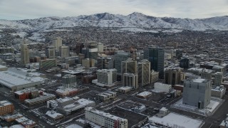 AX124_209 - 5.5K stock footage aerial video of circling snowy Downtown Salt Lake City in winter at sunrise in Utah