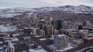 AX124_209E - 5.5K aerial stock footage of circling snowy Downtown Salt Lake City in winter at sunrise in Utah