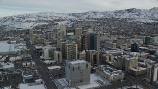 AX124_210 - 5.5K aerial stock footage of circling Downtown Salt Lake City buildings with winter snow at sunrise, Utah