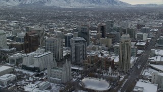 AX124_223 - 5.5K stock footage aerial video of Downtown Salt Lake City and Salt Lake Temple in winter snow at sunrise, Utah
