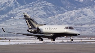 AX124_235E - 5.5K aerial stock footage track jet airplane in winter at the Salt Lake City International Airport at sunrise in Utah