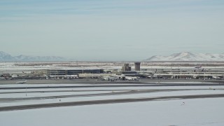 AX125_001E - 5.5K aerial stock footage of Salt Lake City International Airport revealing commercial jet in winter, Utah