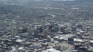 AX125_006E - 5.5K aerial stock footage tilt from freeway to reveal Downtown Salt Lake City with winter snow, Utah