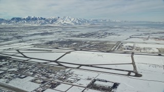 AX125_010 - 5.5K aerial stock footage of Salt Lake City International Airport and jet on runway with winter snow in Utah