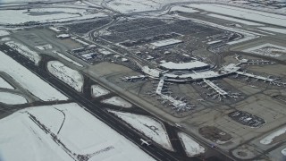 AX125_013E - 5.5K aerial stock footage of terminals at SLC Airport with winter snow in Utah