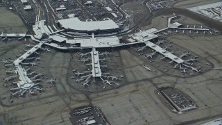 AX125_015 - 5.5K aerial stock footage orbit Salt Lake City International Airport terminals with airliners and winter snow, Utah