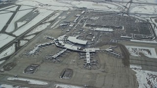 AX125_016 - 5.5K aerial stock footage of orbiting SLC Airport terminals and parking lots with winter snow in Utah