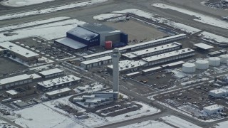 AX125_017 - 5.5K aerial stock footage of a reverse view of control tower at Salt Lake City International Airport in winter, Utah