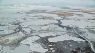 AX125_021 - 5.5K aerial stock footage of ice and snow in a frozen marshland near Salt Lake City, Utah