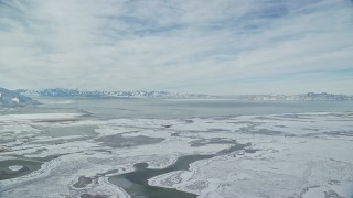 AX125_024 - 5.5K aerial stock footage of snow mountains across the Great Salt Lake in Utah
