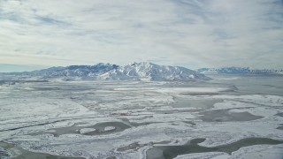 AX125_025 - 5.5K aerial stock footage of snowy Oquirrh Mountains by the shore of Great Salt Lake in winter, Utah