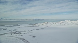 AX125_026 - 5.5K aerial stock footage of Great Salt Lake and Antelope Island with snow mountains in winter in Utah