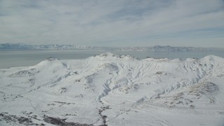 AX125_033 - 5.5K aerial stock footage of snowy Antelope Island mountains in wintertime Utah