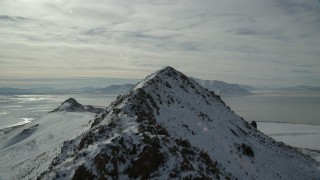AX125_050 - 5.5K aerial stock footage fly over and approach rocky peaks on Antelope Island in winter, Utah