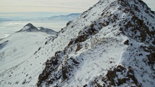 AX125_065 - 5.5K aerial stock footage circle a snowy peak to reveal bighorn sheep on Antelope Island, Utah