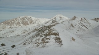 AX125_089 - 5.5K aerial stock footage pan across mountains with winter snow on Antelope Island, Utah