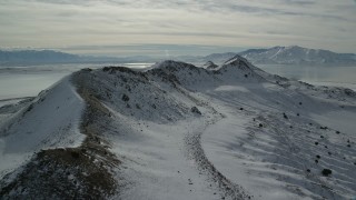 AX125_093 - 5.5K aerial stock footage approach and flyby a snowy mountain ridge on Antelope Island, Utah