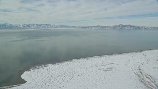 AX125_100E - 5.5K aerial stock footage of Great Salt Lake with patches of ice seen from Antelope Island in winter, Utah
