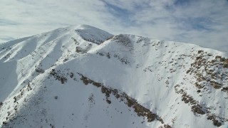 AX125_123E - 5.5K aerial stock footage approach the summit of Kessler Peak in the Oquirrh Mountains in winter, Utah