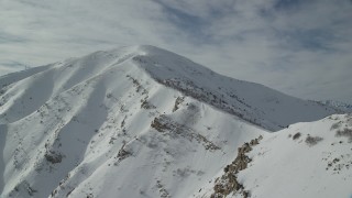 AX125_125 - 5.5K aerial stock footage approach frozen Kessler Peak in wintery Utah
