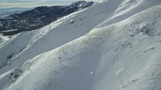 AX125_128 - 5.5K aerial stock footage flyby thick snow on Kessler Peak slopes in winter, Utah
