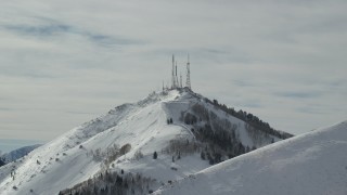 AX125_129 - 5.5K aerial stock footage tilt to radio towers on the frozen summit of Farnsworth Peak, Utah