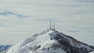 AX125_129E - 5.5K aerial stock footage of radio towers on the frozen summit of Farnsworth Peak, Utah