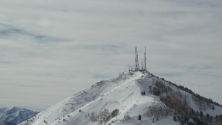 AX125_130 - 5.5K aerial stock footage of radio towers on summit of Farnsworth Peak with winter snow, Utah