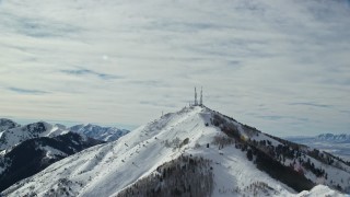 AX125_131 - 5.5K aerial stock footage approach radio towers on Farnsworth Peak with winter snow, Utah