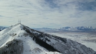 AX125_132 - 5.5K aerial stock footage of radio towers on Farnsworth Peak and snow valley in distance, Utah