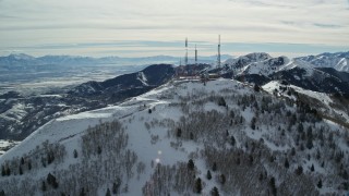 AX125_133E - 5.5K aerial stock footage of radio towers on Farnsworth Peak's summit with winter snow in Utah