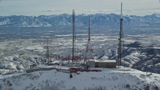 AX125_136 - 5.5K aerial stock footage orbit radio transmission towers on Farnsworth Peak with winter snow, Utah
