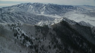 AX125_145 - 5.5K aerial stock footage of snowy mountain ridges in Utah's Oquirrh Mountains in winter