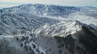 AX125_145E - 5.5K aerial stock footage of snowy mountain ridges in Utah's Oquirrh Mountains in winter